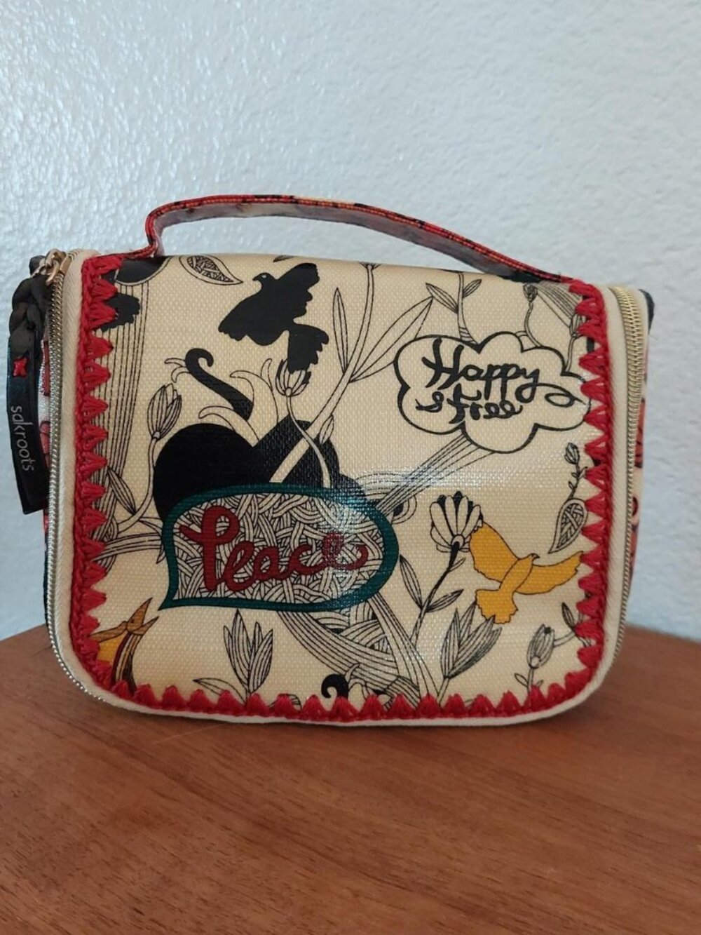 Sakroots mini purse with red floral and heart design on cream background #floral